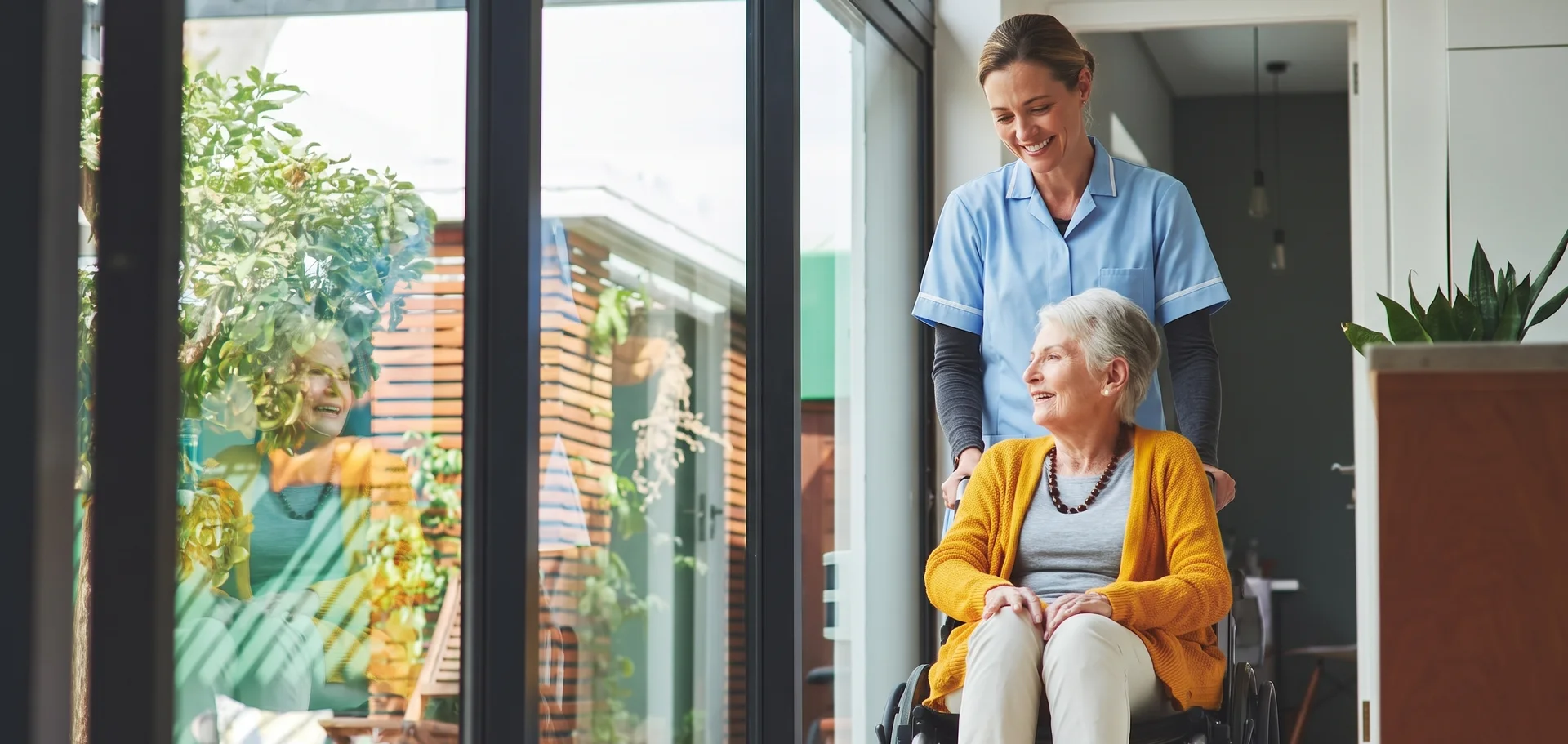 Journey Medical Care Group caregiver walking beside an elderly resident in a wheelchair at a Texas long-term care community
